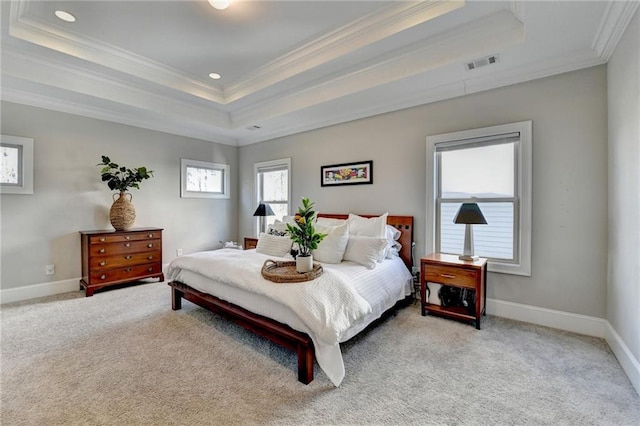 bedroom featuring ornamental molding, light colored carpet, and a tray ceiling