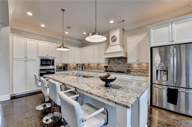 kitchen with pendant lighting, stainless steel appliances, sink, and white cabinets