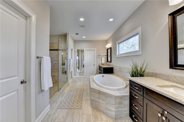 bathroom with vanity and independent shower and bath