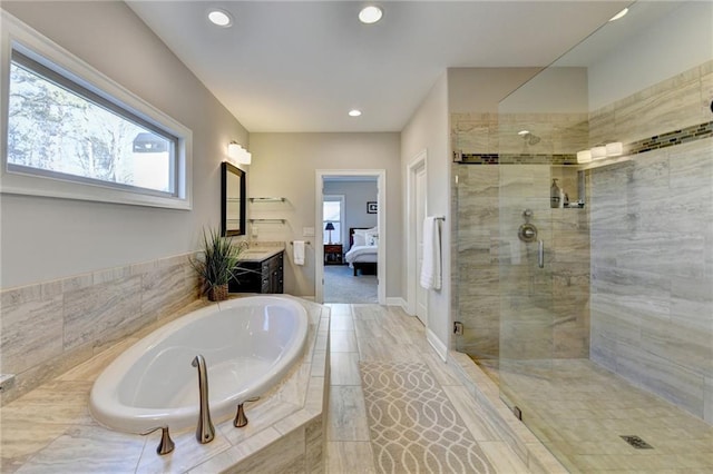 bathroom featuring shower with separate bathtub and vanity