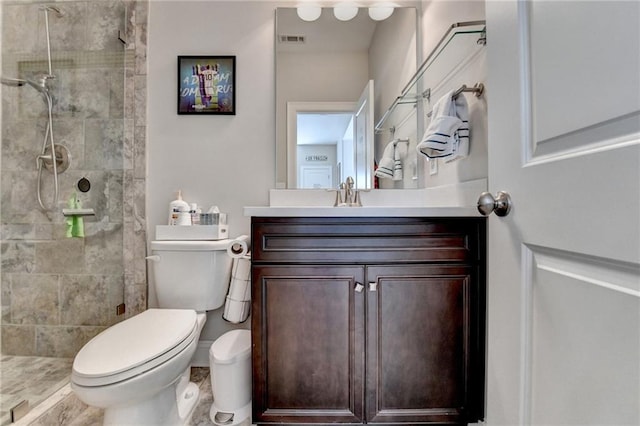 bathroom featuring tiled shower, vanity, and toilet