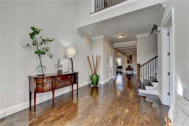 foyer entrance with ornamental molding and dark hardwood / wood-style floors