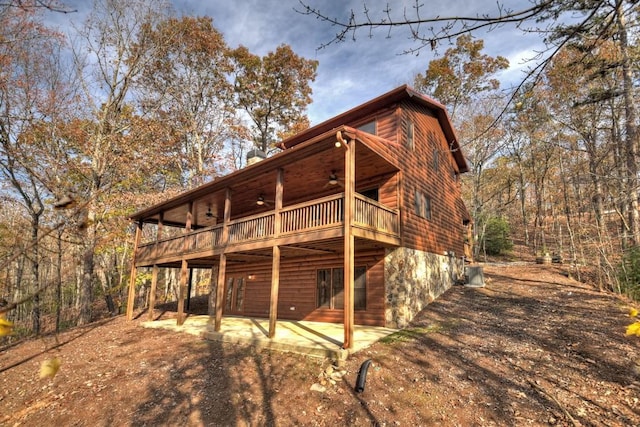 back of house with ceiling fan, a balcony, a deck, and a patio