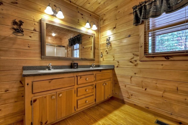 bathroom with hardwood / wood-style floors, vanity, wood walls, and wood ceiling