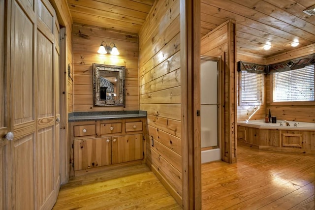 interior space featuring light hardwood / wood-style floors, wood ceiling, and wooden walls