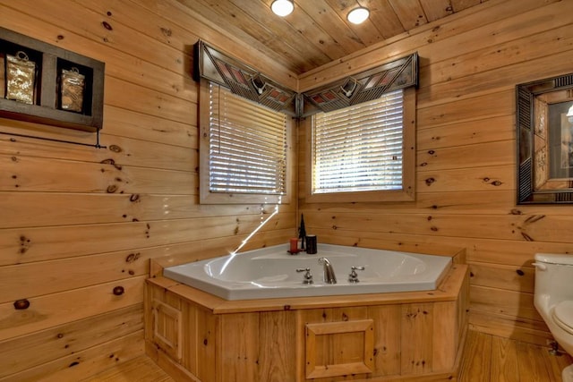 bathroom with wood walls, wooden ceiling, hardwood / wood-style flooring, toilet, and a tub