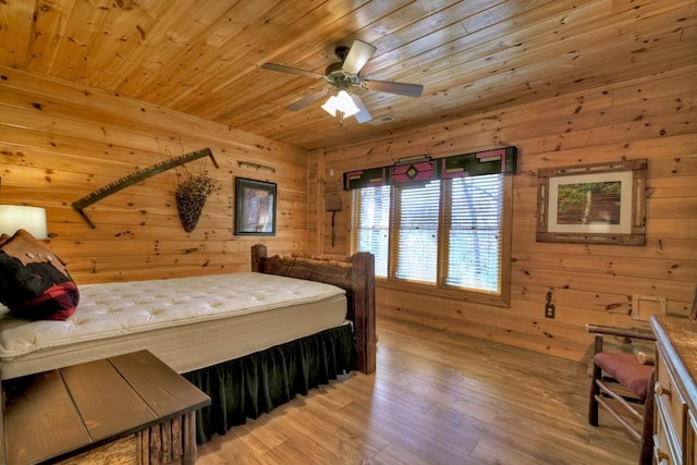 bedroom with ceiling fan, wood walls, wooden ceiling, and light hardwood / wood-style flooring