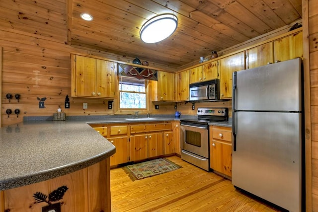 kitchen featuring sink, stainless steel appliances, light hardwood / wood-style flooring, wooden walls, and wood ceiling