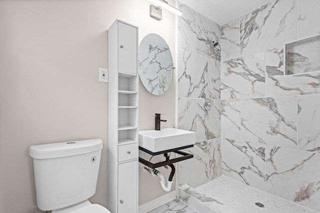 2617 Peggy Sue Ln, Morrow, GA 30260 - bathroom featuring marble finish flooring, tiled shower, a sink, and toilet