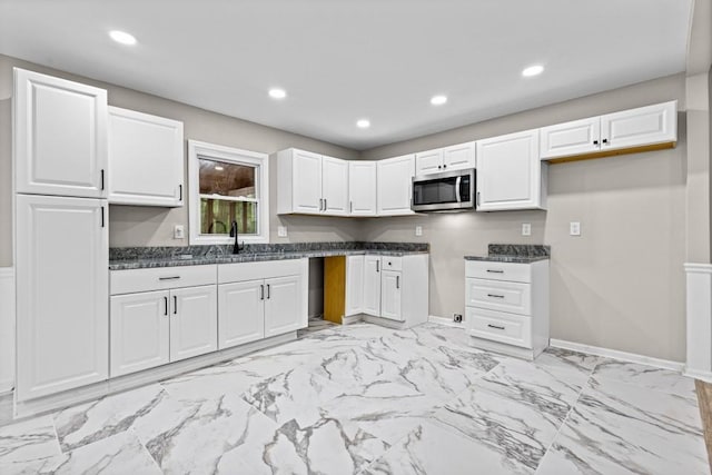 2617 Peggy Sue Ln, Morrow, GA 30260 - kitchen with stainless steel microwave, dark countertops, white cabinetry, recessed lighting, and light marble finish flooring