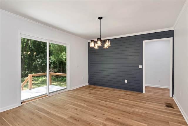 unfurnished dining area featuring ornamental molding, a chandelier, and light hardwood / wood-style flooring