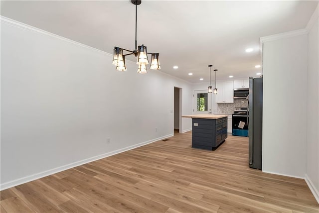 kitchen with a center island, hanging light fixtures, appliances with stainless steel finishes, light hardwood / wood-style floors, and white cabinets