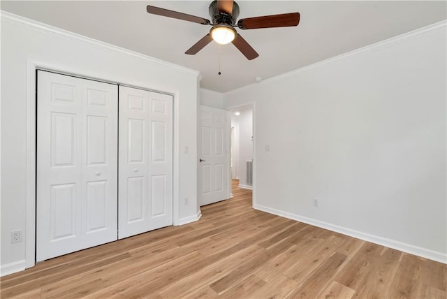 unfurnished bedroom with crown molding, light hardwood / wood-style flooring, a closet, and ceiling fan