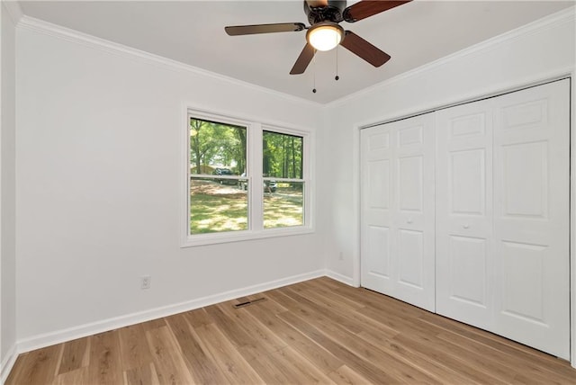 unfurnished bedroom with ornamental molding, a closet, ceiling fan, and light wood-type flooring