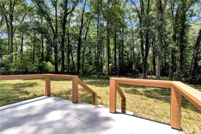 wooden deck featuring a patio area and a lawn