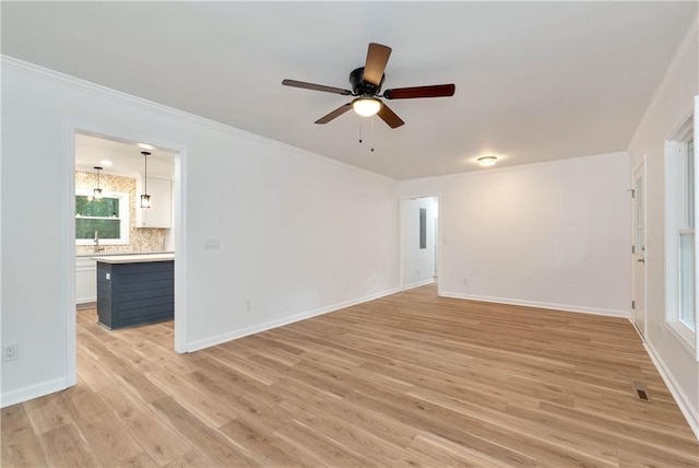 spare room featuring sink, crown molding, ceiling fan, and light wood-type flooring