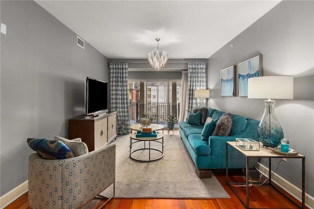 living room with hardwood / wood-style flooring and an inviting chandelier