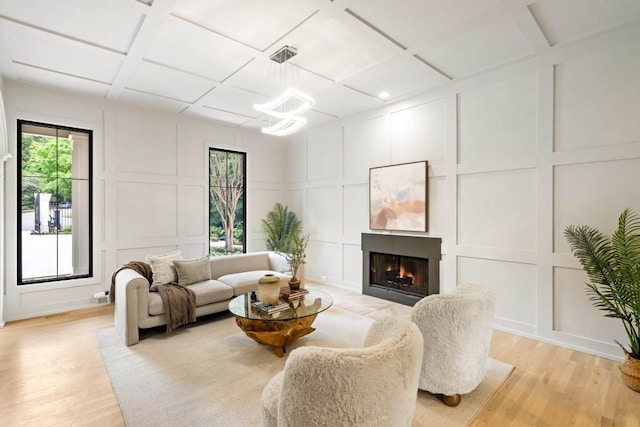 1430 N Harris Rdg, Atlanta, GA 30327 - living room featuring a decorative wall, healthy amount of natural light, a warm lit fireplace, light wood-style floors, and coffered ceiling