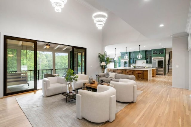 1430 N Harris Rdg, Atlanta, GA 30327 - living room featuring light wood-type flooring, crown molding, a chandelier, a high ceiling, and a ceiling fan