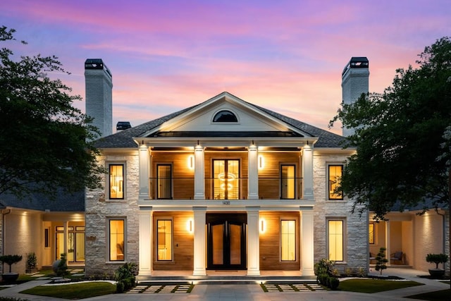 1430 N Harris Rdg, Atlanta, GA 30327 - back of property at dusk with a balcony, a porch, french doors, stone siding, and a chimney