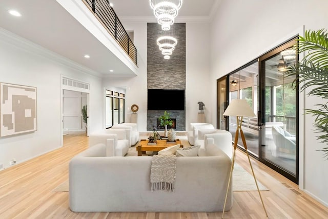 1430 N Harris Rdg, Atlanta, GA 30327 - living room featuring a chandelier, light wood-style floors, crown molding, a fireplace, and a towering ceiling