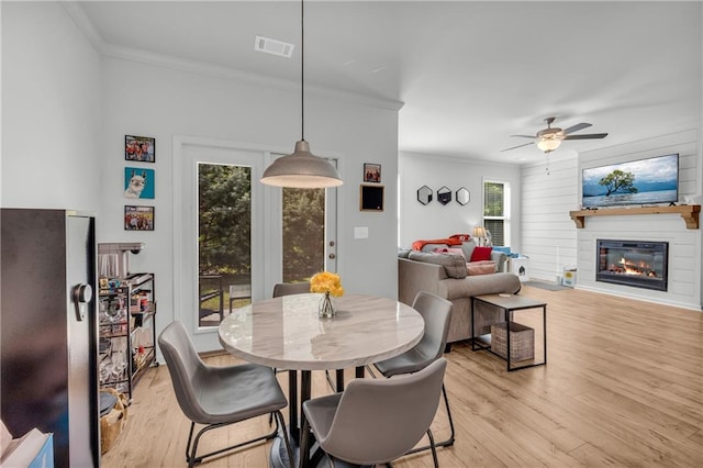 5615 Parkview Ln, Flowery Branch, GA 30542 - dining room with crown molding, light wood-style flooring, a fireplace, and ceiling fan