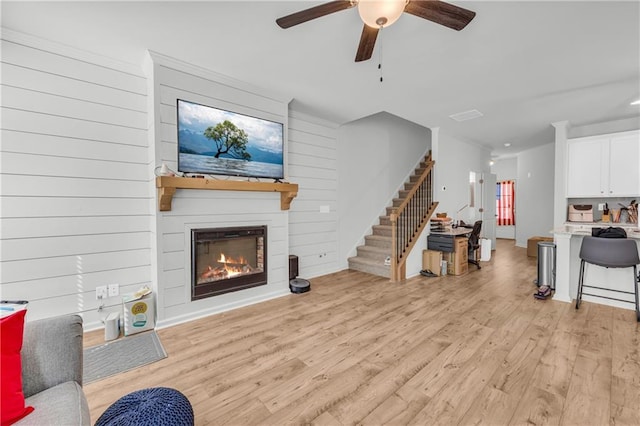 5615 Parkview Ln, Flowery Branch, GA 30542 - living area with stairs, ceiling fan, light wood-style flooring, and a fireplace