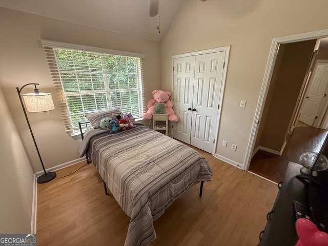 3269 N Winds Trl N, Douglasville, GA 30135 - bedroom with vaulted ceiling, baseboards, wood finished floors, a closet, and a ceiling fan
