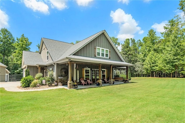 rear view of house with a yard and a porch