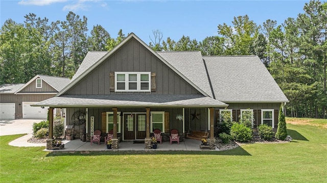 back of house with a garage and a lawn