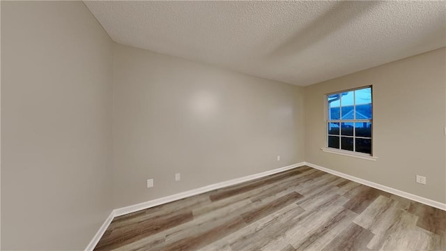 empty room featuring hardwood / wood-style floors and a textured ceiling