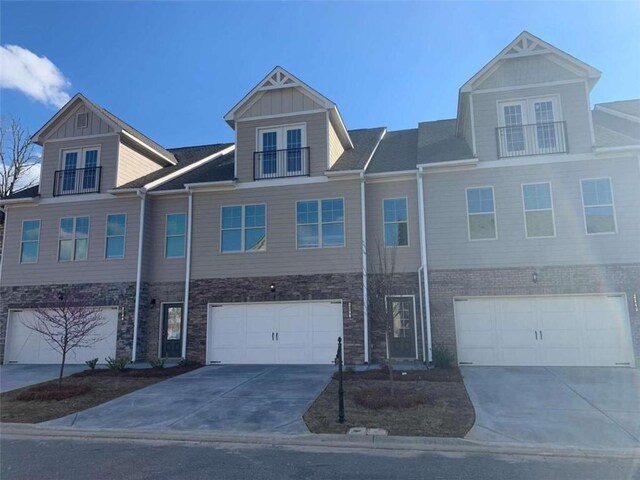 2040 Manor Pointe Dr, Cumming, GA 30041 - view of property featuring concrete driveway, an attached garage, french doors, and stone siding