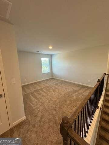 unfurnished room with dark carpet