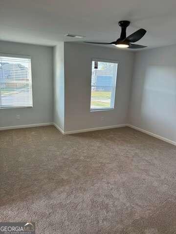 carpeted spare room featuring ceiling fan