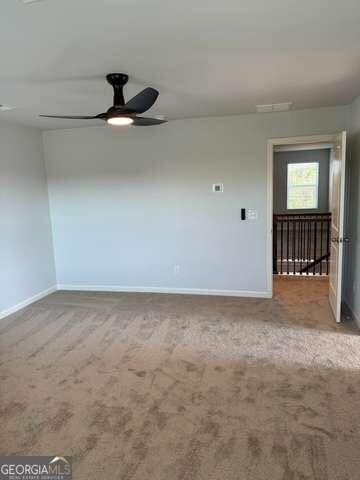 spare room with carpet and ceiling fan