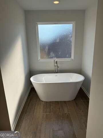 bathroom with wood-type flooring and a bathing tub