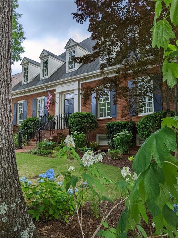 cape cod home featuring brick siding