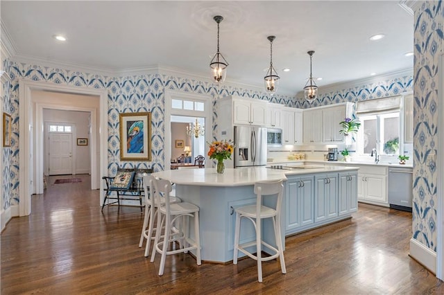 kitchen with stainless steel appliances, ornamental molding, light countertops, and white cabinetry