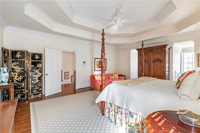 bedroom featuring ceiling fan, wood finished floors, a raised ceiling, and crown molding