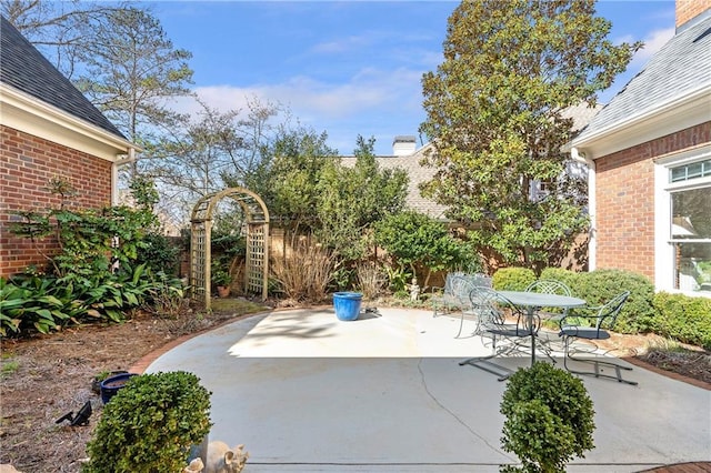 view of patio with outdoor dining space and fence