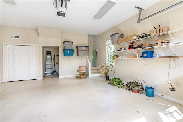 garage featuring baseboards, visible vents, and a garage door opener