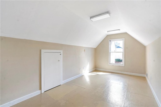 additional living space with vaulted ceiling and baseboards