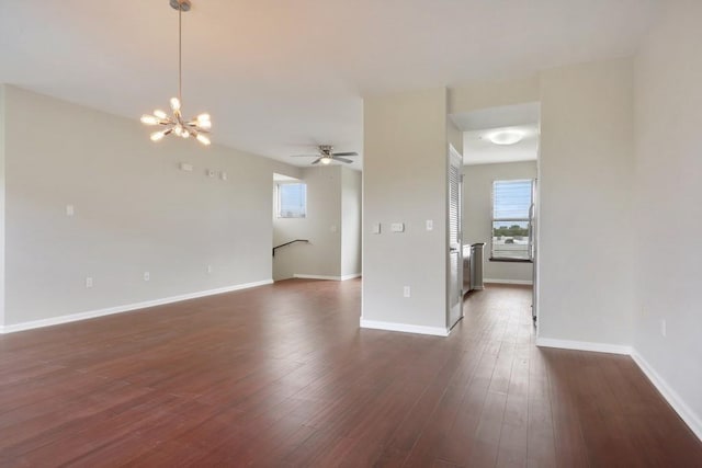 unfurnished room featuring ceiling fan with notable chandelier and dark hardwood / wood-style flooring