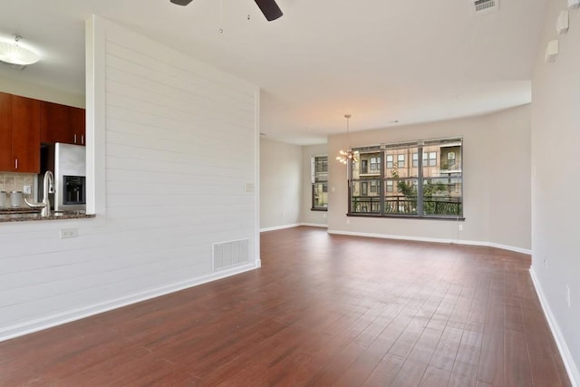 unfurnished living room with dark wood-type flooring and ceiling fan