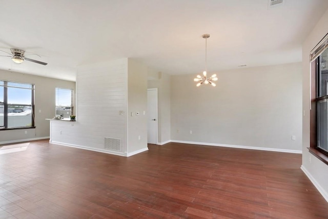 unfurnished room with dark wood-type flooring and ceiling fan with notable chandelier