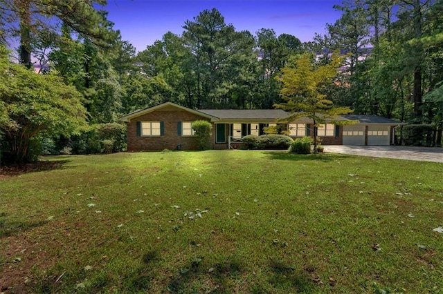 ranch-style house with a yard and a garage