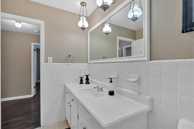 bathroom featuring vanity and tile walls