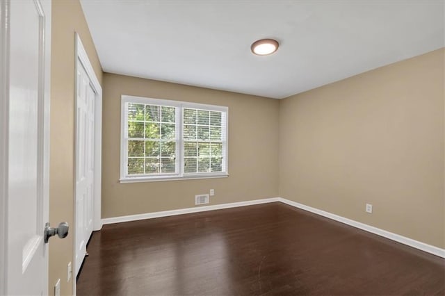 unfurnished room with dark hardwood / wood-style flooring