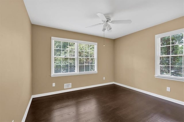 empty room with hardwood / wood-style floors, a wealth of natural light, and ceiling fan