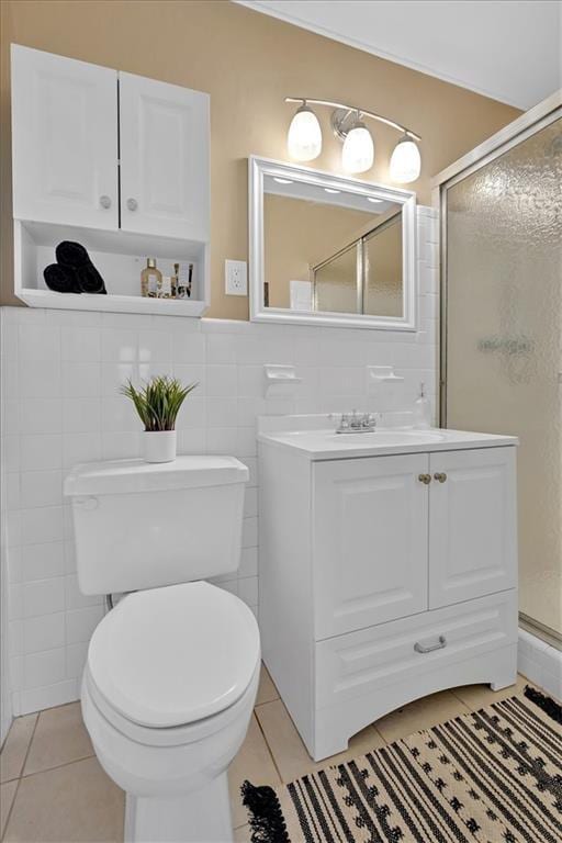 bathroom with tile patterned flooring, vanity, toilet, and tile walls